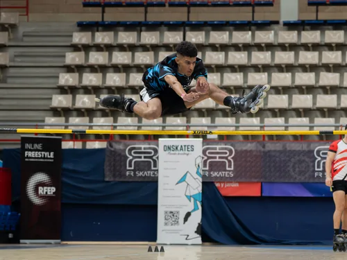 Patinador del Team Onskates lanzándose en horizontal sobre una valla
