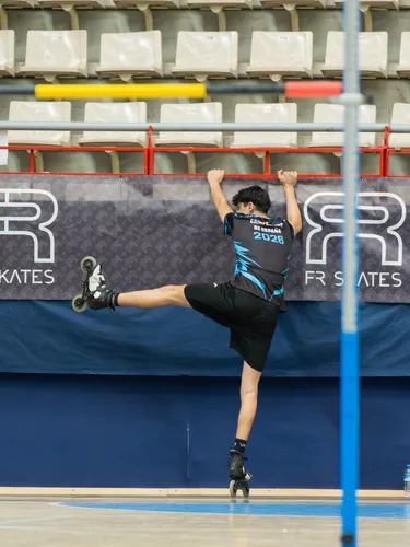 Patinador del Team Onskates sujeto a una barra en pleno salto de altura