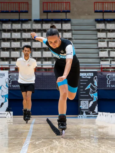 Patinadora del Team Onskates agachada en la salida junto a su entrenador