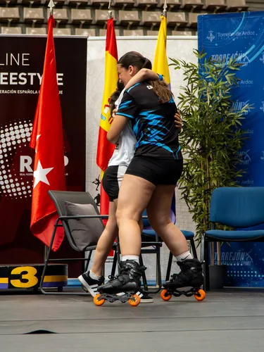 Patinadoras del Team Onskates abrazadas junto a las banderas de la competición