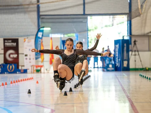 Dos patinadoras del Team Onskates en una coreografía de parejas en plena caída controlada
