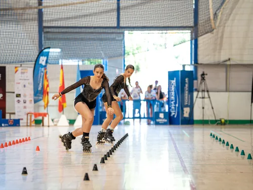 Dos patinadoras del Team Onskates agachadas en sincronía durante su coreografía