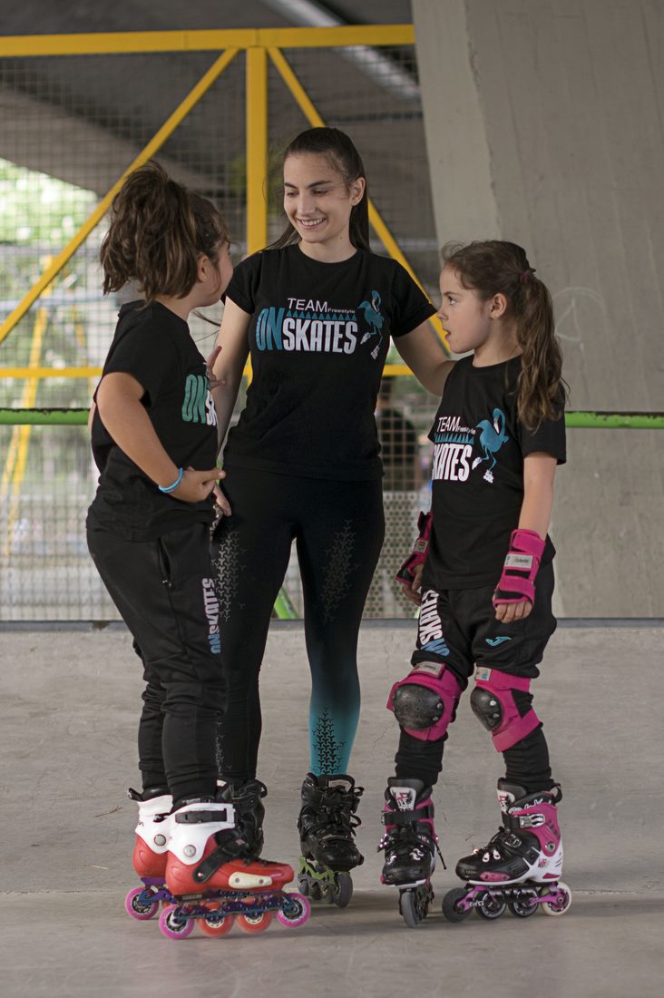 Entrenadora de Onskates acompañando a dos alumnas de la Escuela sobre patines