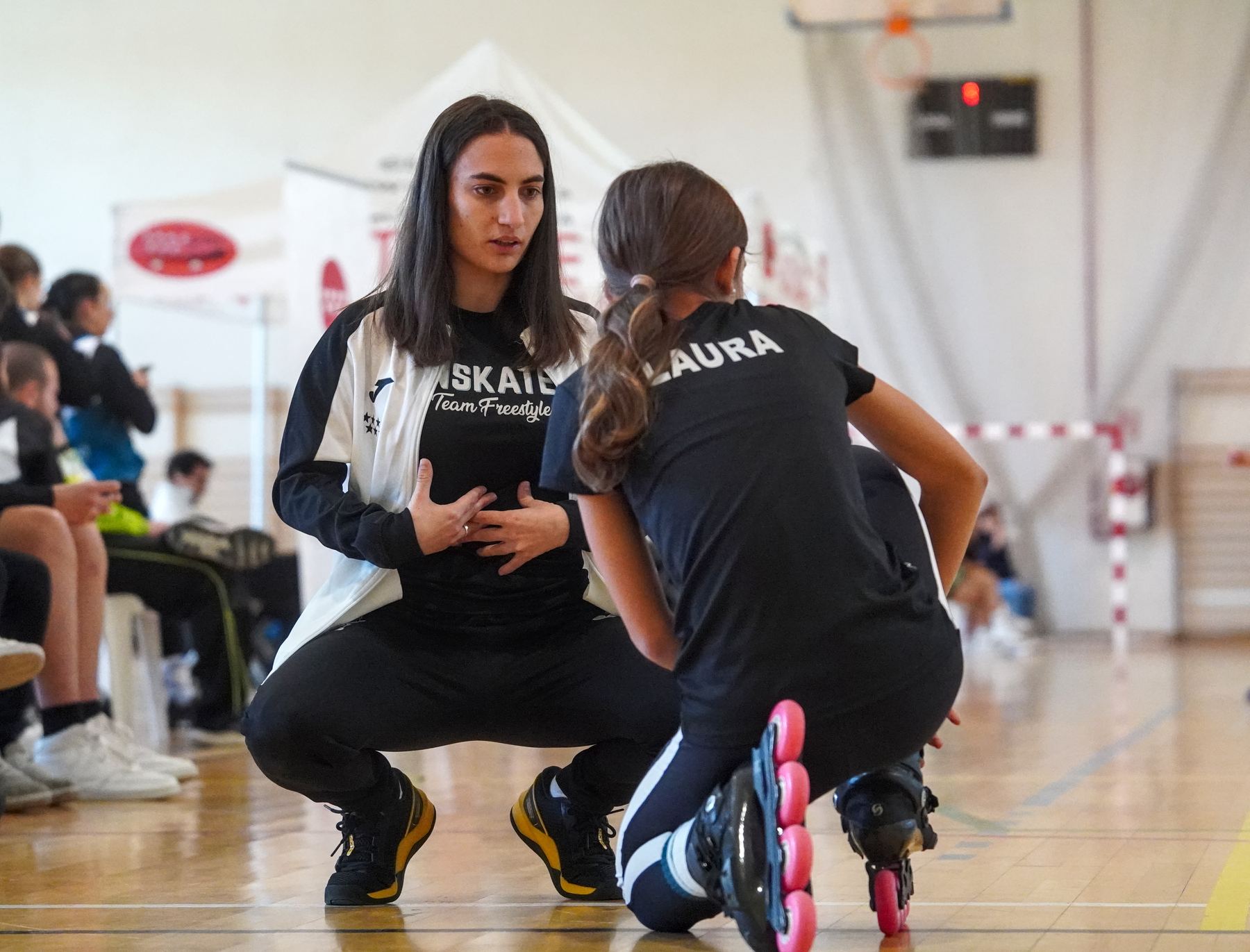 Entrenadora de Onskates explicando un ejercicio a una joven patinadora