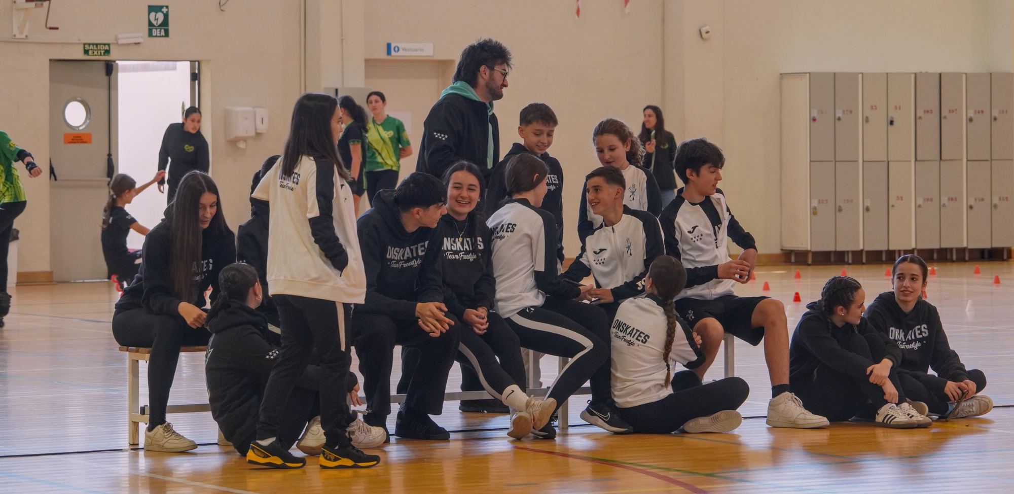 Patinadores del Team Onskates charlando y sonriendo sentados en un banco