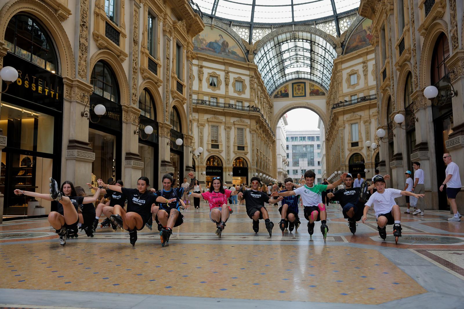 Patinadores del Team Onskates posando en línea sobre patines en la Galleria Vittorio Emanuele II de Milán